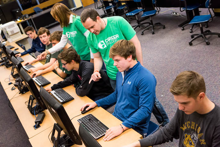 Slide Show Image #1: Students working at bank of computers, guieded by two CareerBuilder employees